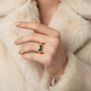 Gold ring with a green gemstone on a white background