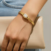 Gold bracelet with a diamond on a wrist, wearing denim jeans