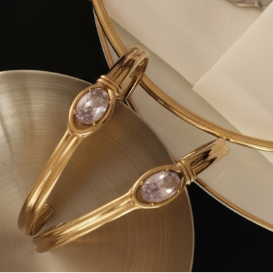 Gold bracelet with gemstones on a white napkin with silver cutlery